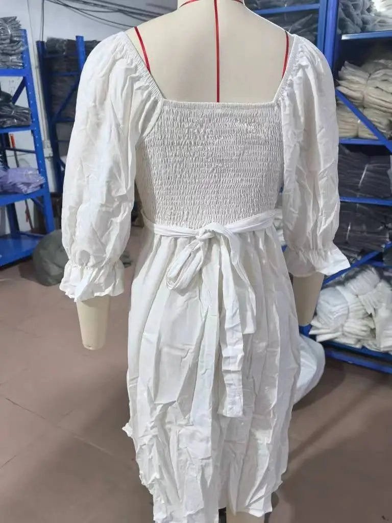 white cotton v-neck lantern sleeve reversible midi dress shown from the back with puffed sleeves and a smocked detail