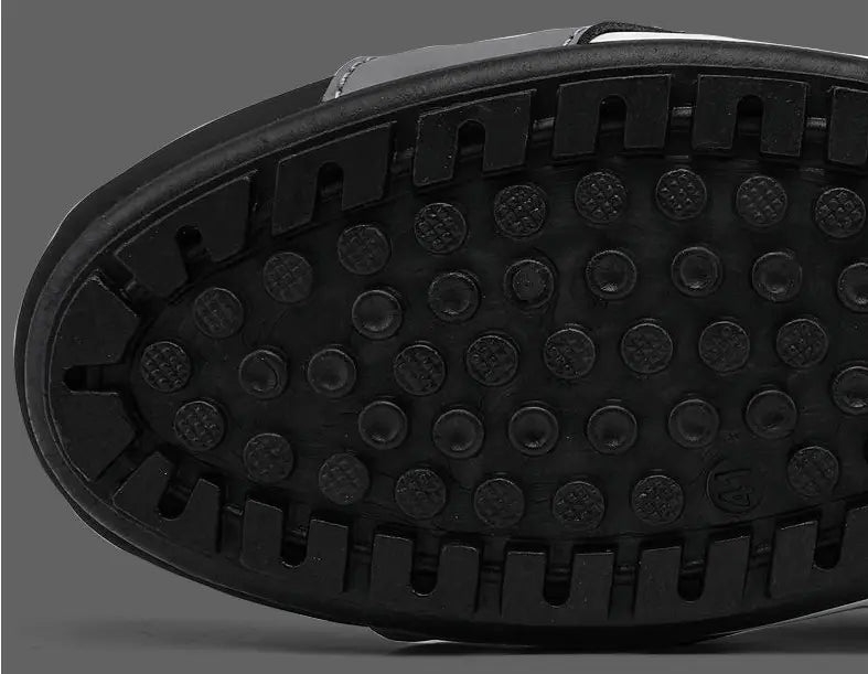 Black rubber sole with circular studs and rectangular lugs of men’s low top quilted athletic fashion sneakers.