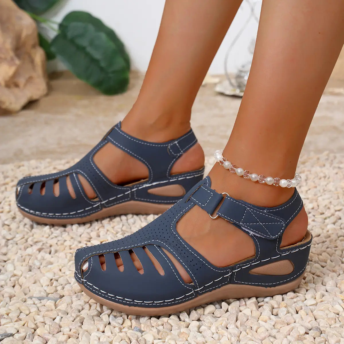 Sandales compensées en cuir bleu marine pour femmes, avec surpiqûres blanches et une bride traversant le pied, design d’été au style romain.
