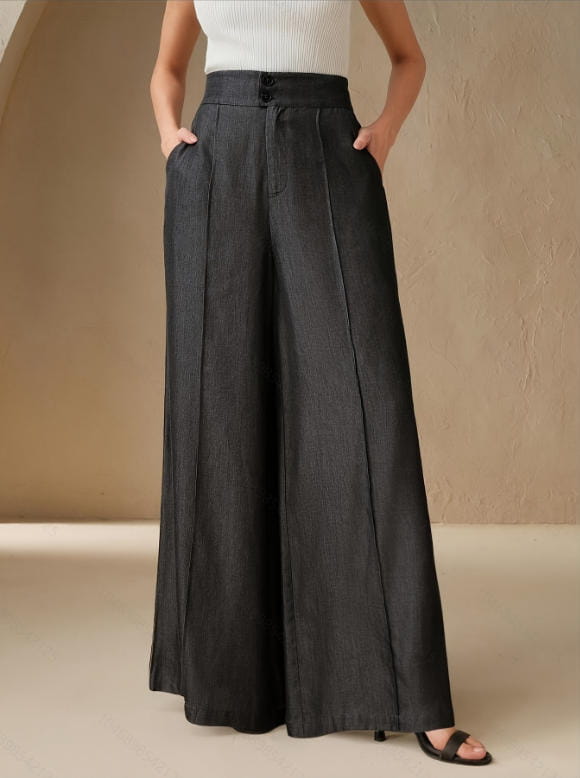 Black high waisted wide leg trousers with button closure and front pockets displayed on a white background.