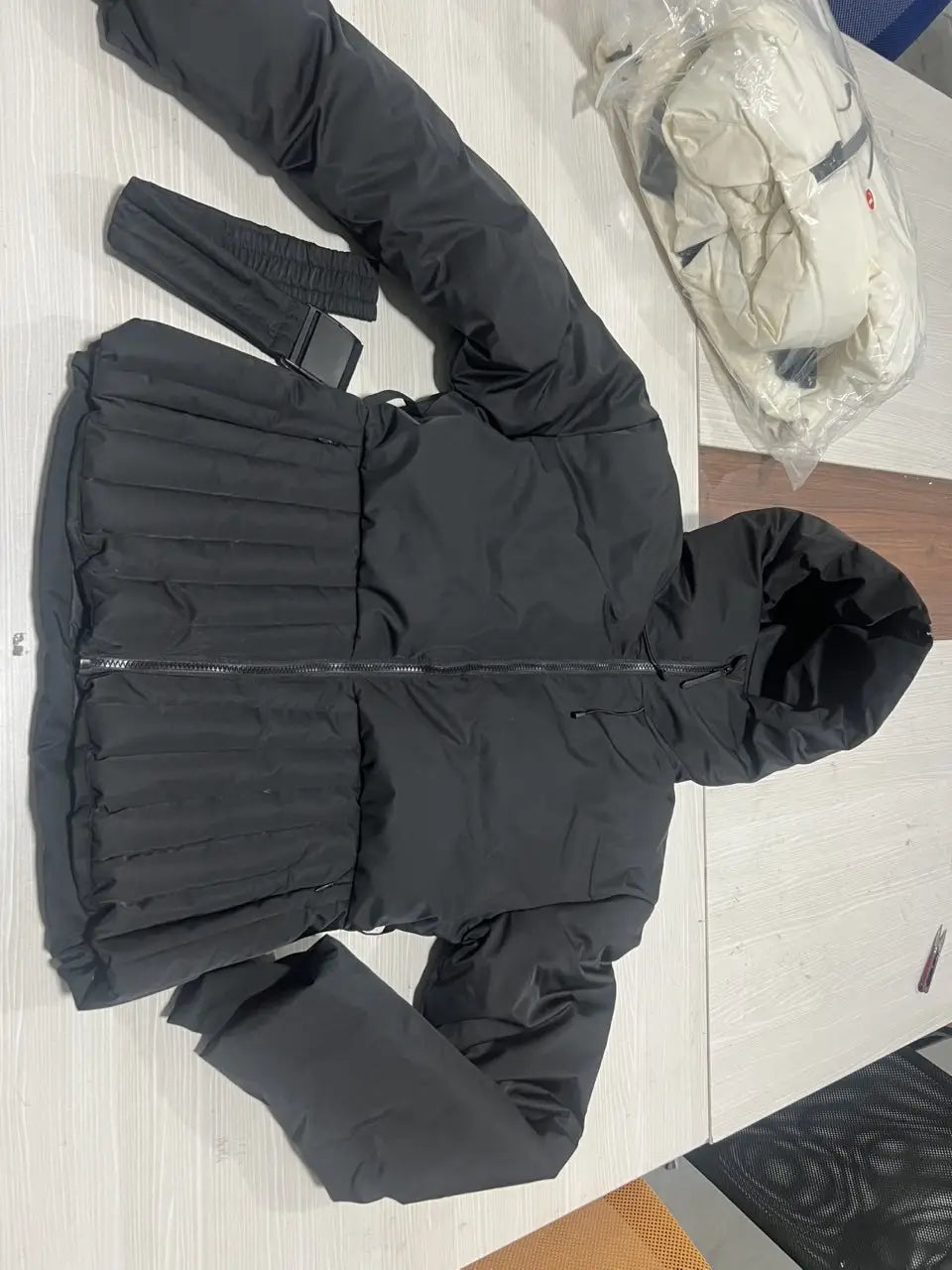 Black women’s belted hooded puffer coat with quilted design and hood made from insulated material for cold weather.