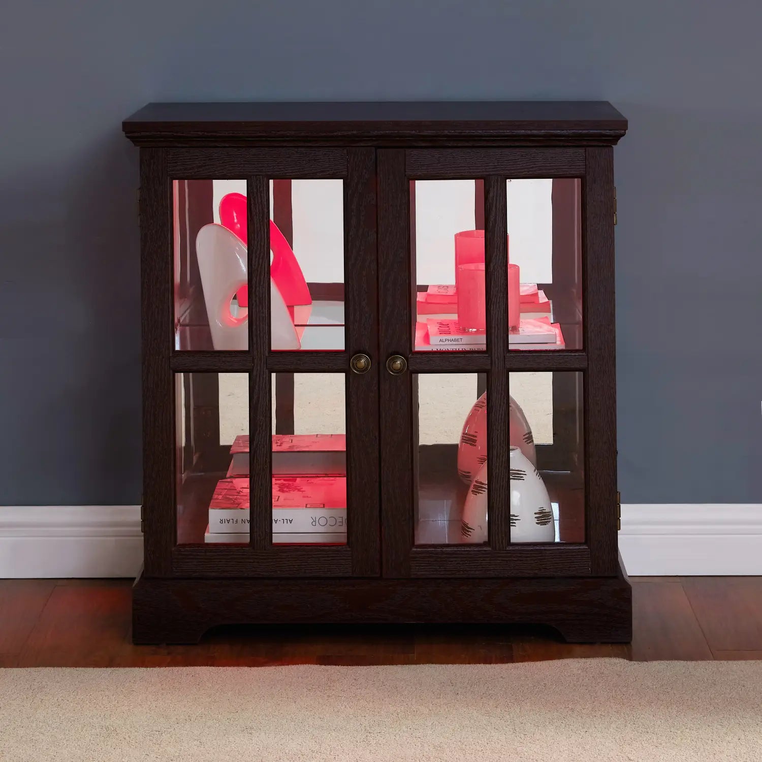 led curio display cabinet made of dark wood with glass doors, brass knobs, and adjustable shelves for showcasing collectibles.