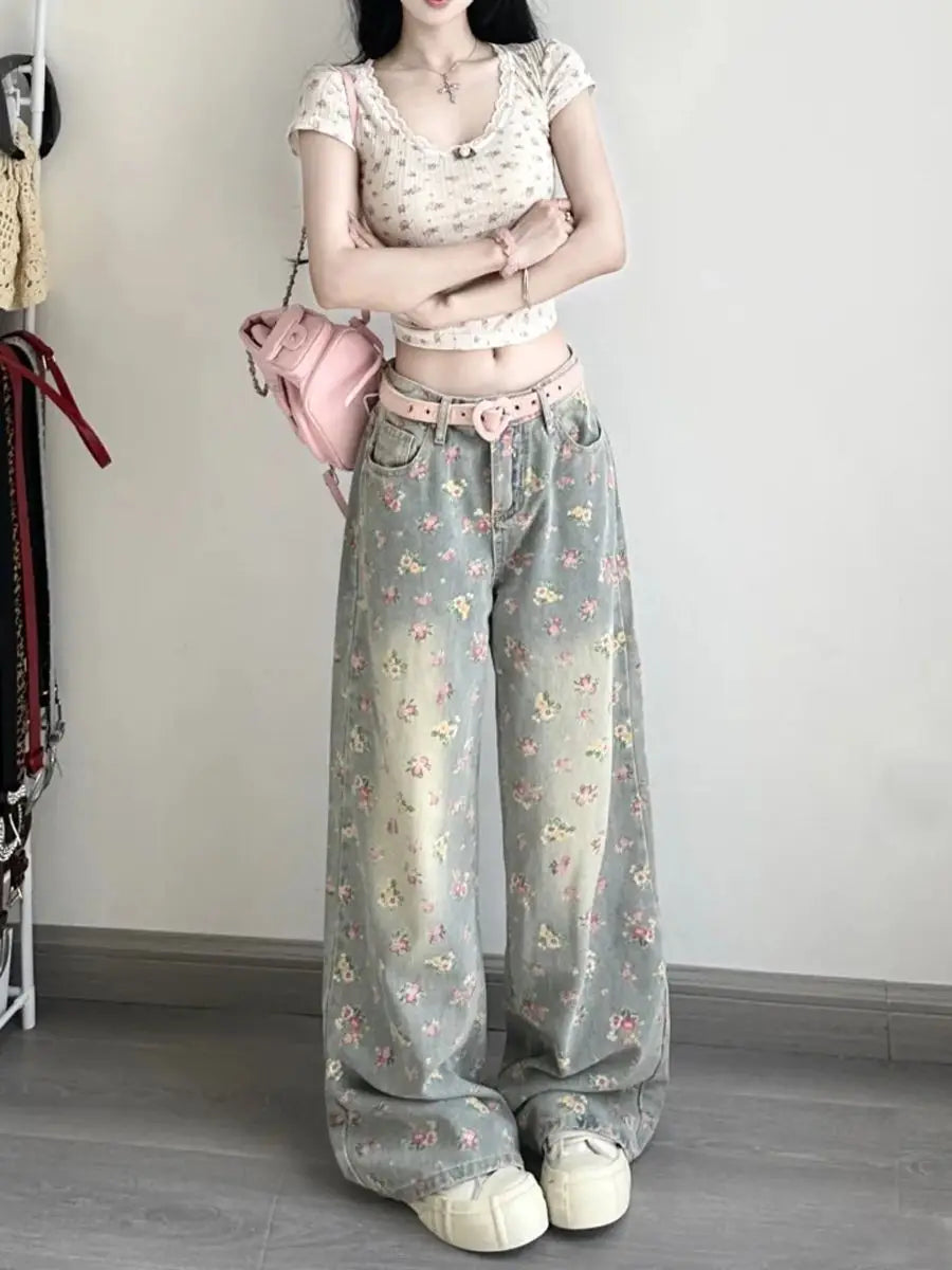 Floral high waist wide leg denim jeans in faded mint green with delicate pink and yellow blossoms featuring a relaxed fit and subtle distressing.