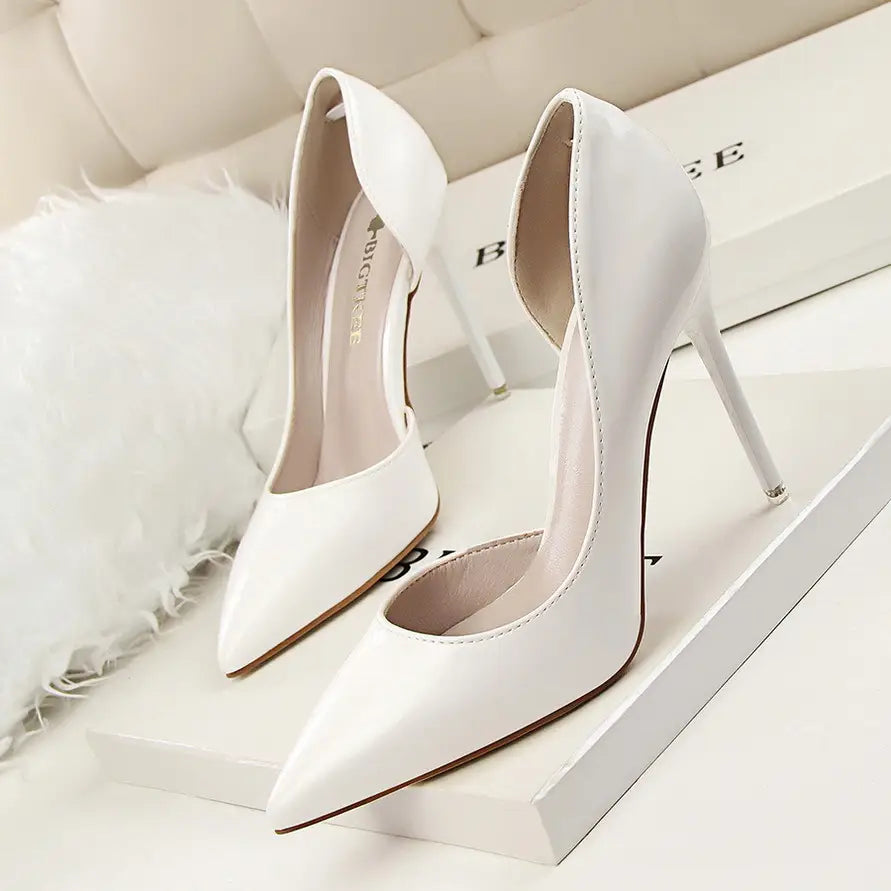 White patent leather stiletto high heels featuring a sleek pointed toe and thin heel.