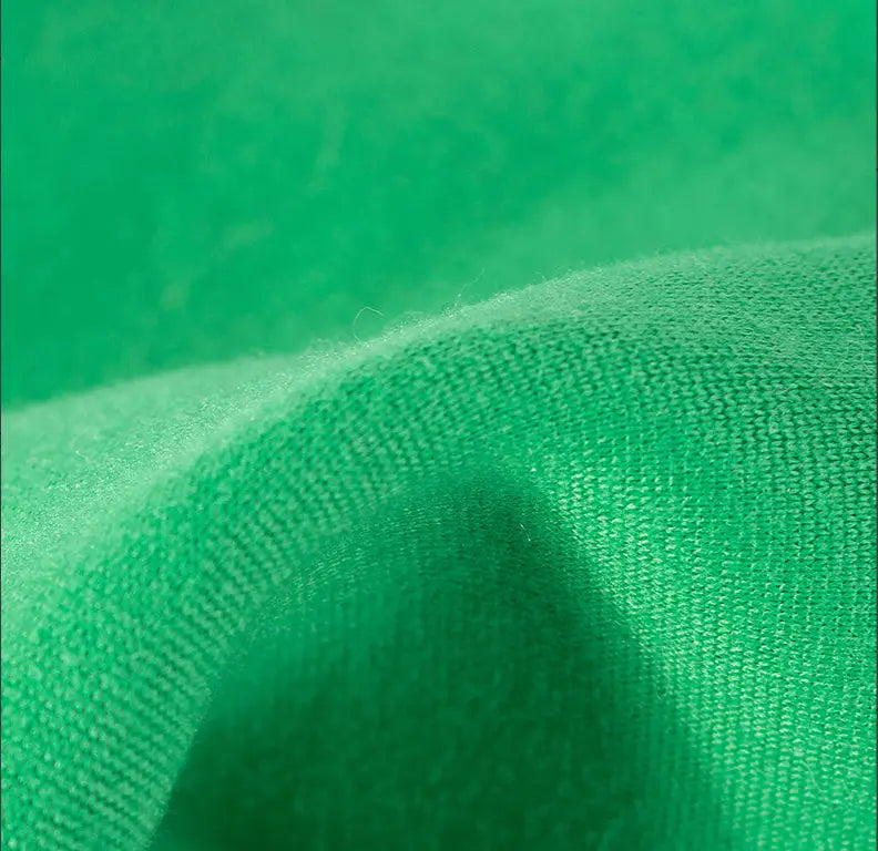 A close-up of the soft vibrant green woven fabric used in the dinosaur cat hoodie plush pet costume.