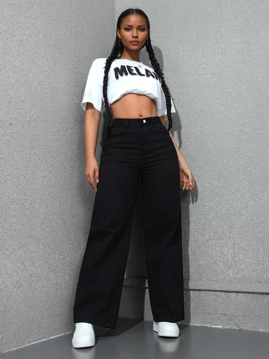 Jean noir à taille haute, jambe large et évasée, fabriqué en denim, présenté de dos.