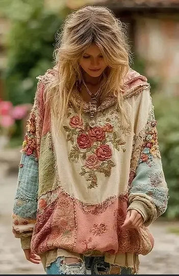 A vintage patchwork floral hoodie with embroidered pink and gold roses on a cream base and sleeves and panels of faded blue green and dusty rose fabrics.