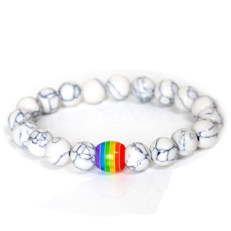 A natural stone bracelet with white and black marbled beads featuring a single rainbow-colored pride accent bead.