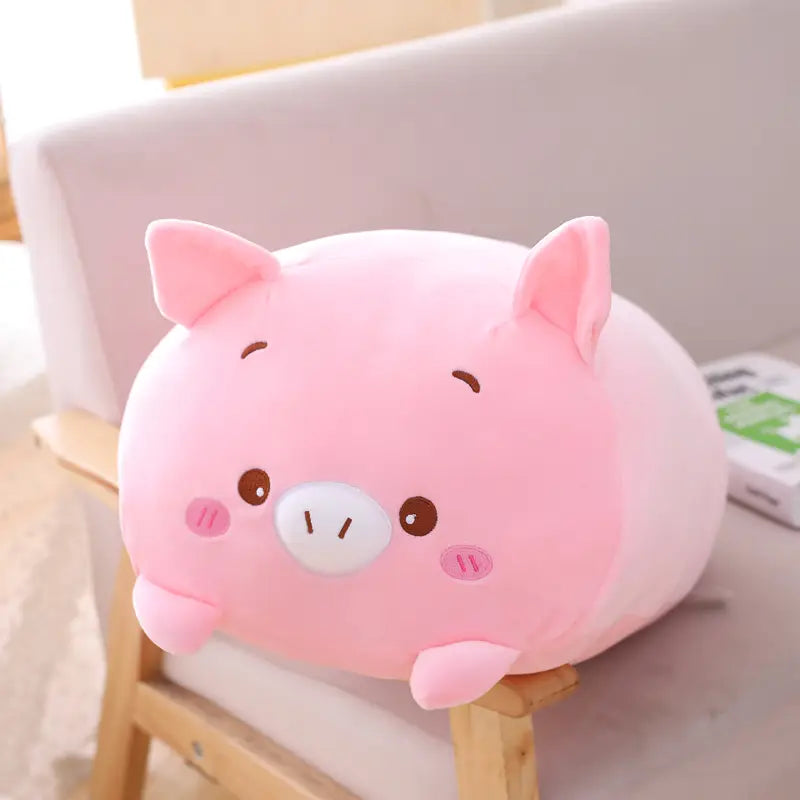 A soft plush pink pig pillow with embroidered brown eyes and a white snout designed as a plush animal pillow soft cartoon doll for kids.