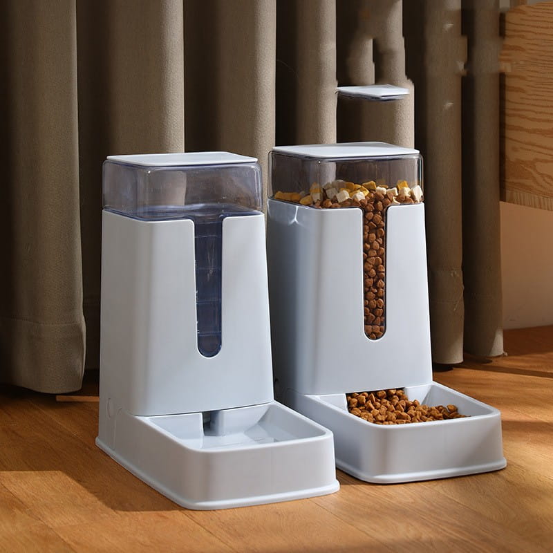 Automatic pet feeder and water dispenser in white plastic with a transparent top and side window filled with dry kibble.