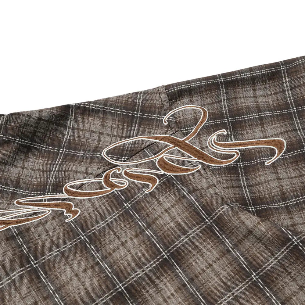 brown plaid fabric short sleeve shirt featuring a cursive embroidered logo in matching brown thread outlined in white