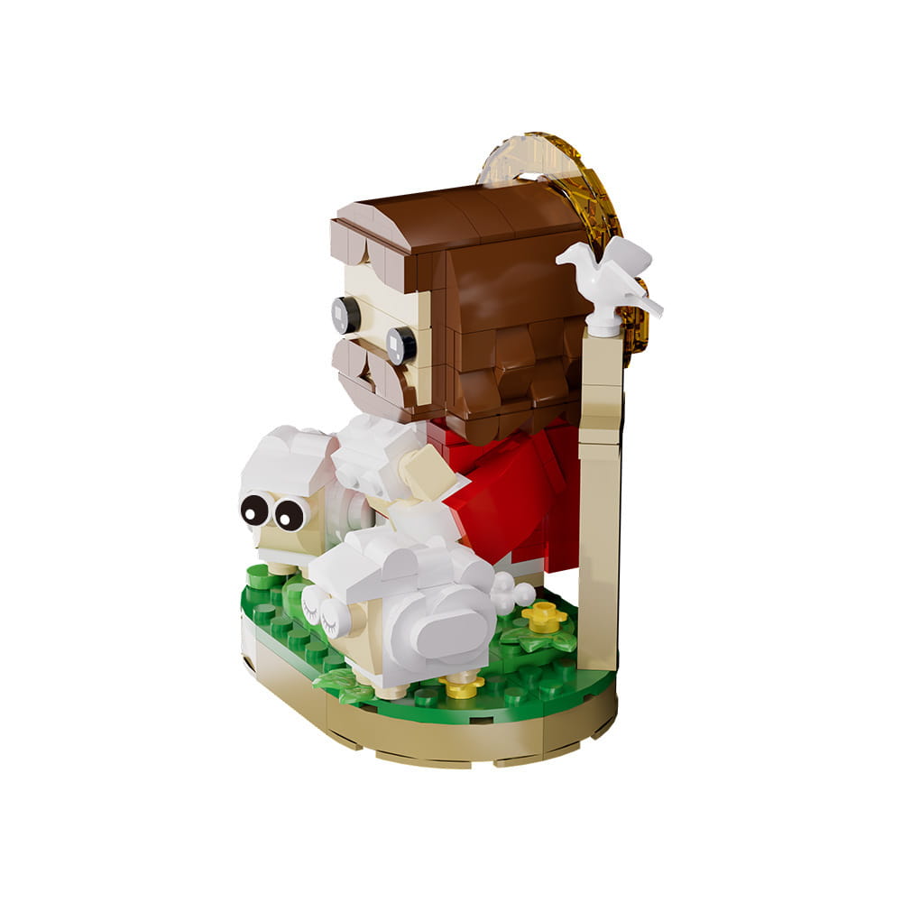 Un modèle de blocs de construction Jésus berger en Lego présentant une figure anguleuse, aux cheveux bruns et à la barbe, portant des robes rouges, assise à côté de deux moutons blancs sur une plaque de base verte.