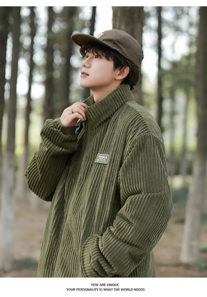 Herren Cord-Pufferjacke für den Winter als warmer Mantel in Olivgrün mit hohem Kragen und kleinem rechteckigem Aufnäher auf der Brust.