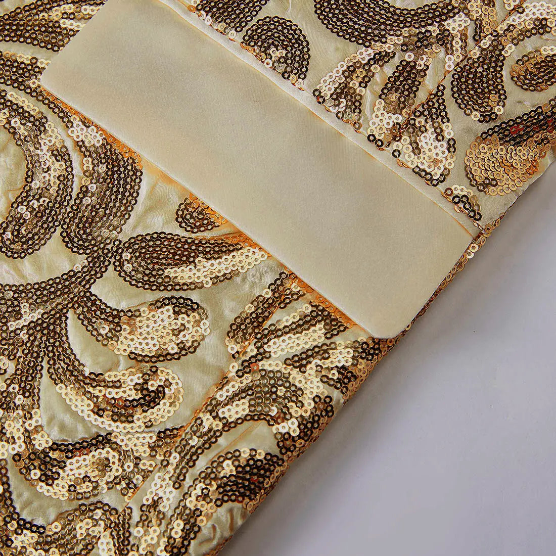 A luxurious cream-colored dress adorned with intricate gold and brown sequin paisley patterns and a smooth satin ribbon trim paired with a gold sequin mens suit jacket retro floral blazer.