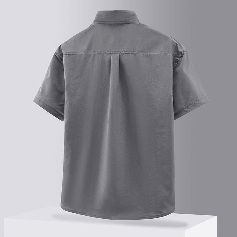Gray short-sleeved solid workwear shirt for men with a collar and subtle pleating at the back shown from the rear side.