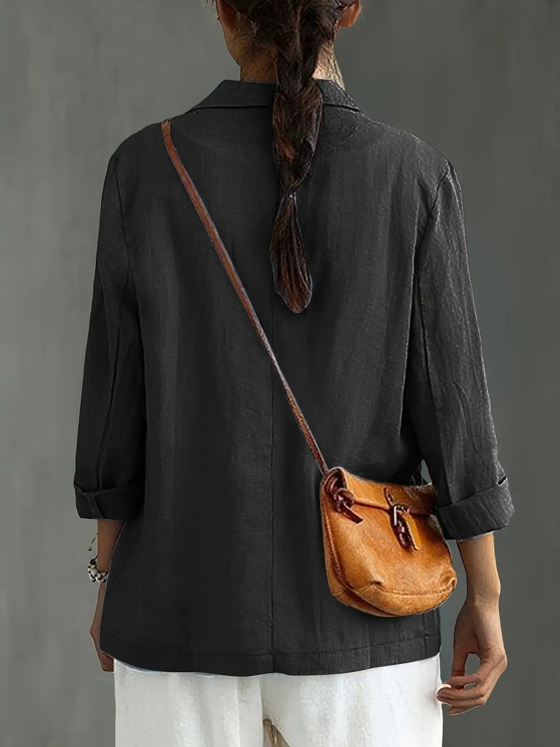 Un bolso cruzado de cuero color camel con cierre de solapa y correa ajustable, combinado con un blazer de lino para mujer, casual y de trabajo.