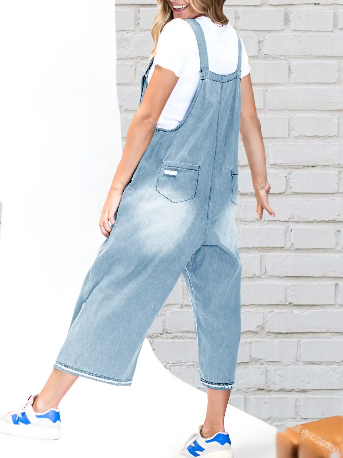 Light-wash denim overalls with wide legs and a casual relaxed fit featuring adjustable straps for women.
