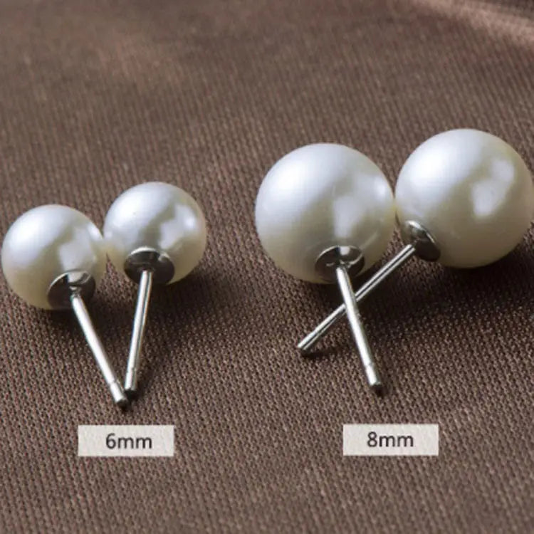 A pair of sterling silver freshwater pearl stud earrings featuring lustrous white spherical pearls with silver-toned metal posts and backs.