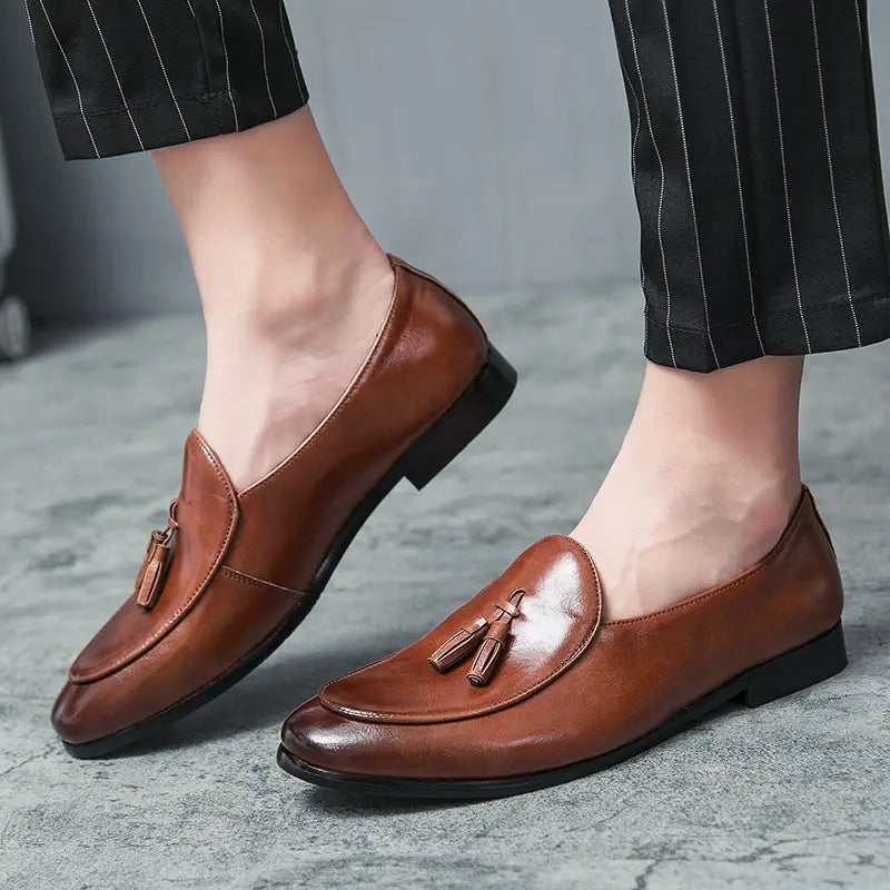 Mocassins à glands britanniques en cuir brun pour jeunes hommes, avec finition polie et semelles noires.