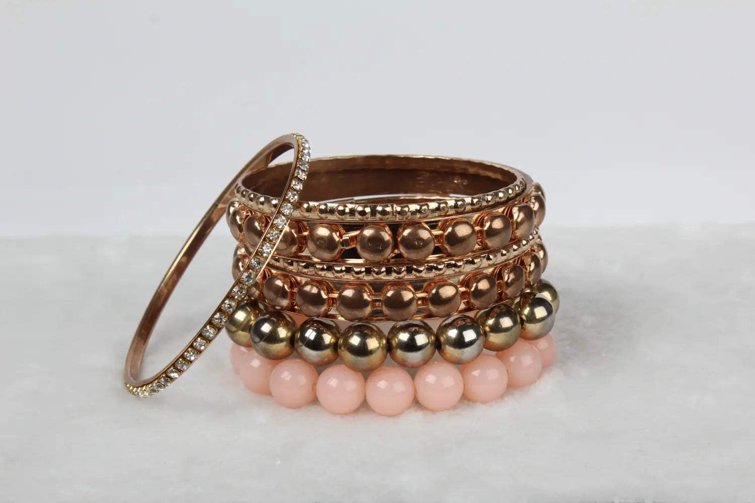 Stack of retro gold and pink rhinestone bangle bracelets featuring rose gold and pink beads with crystal accents.
