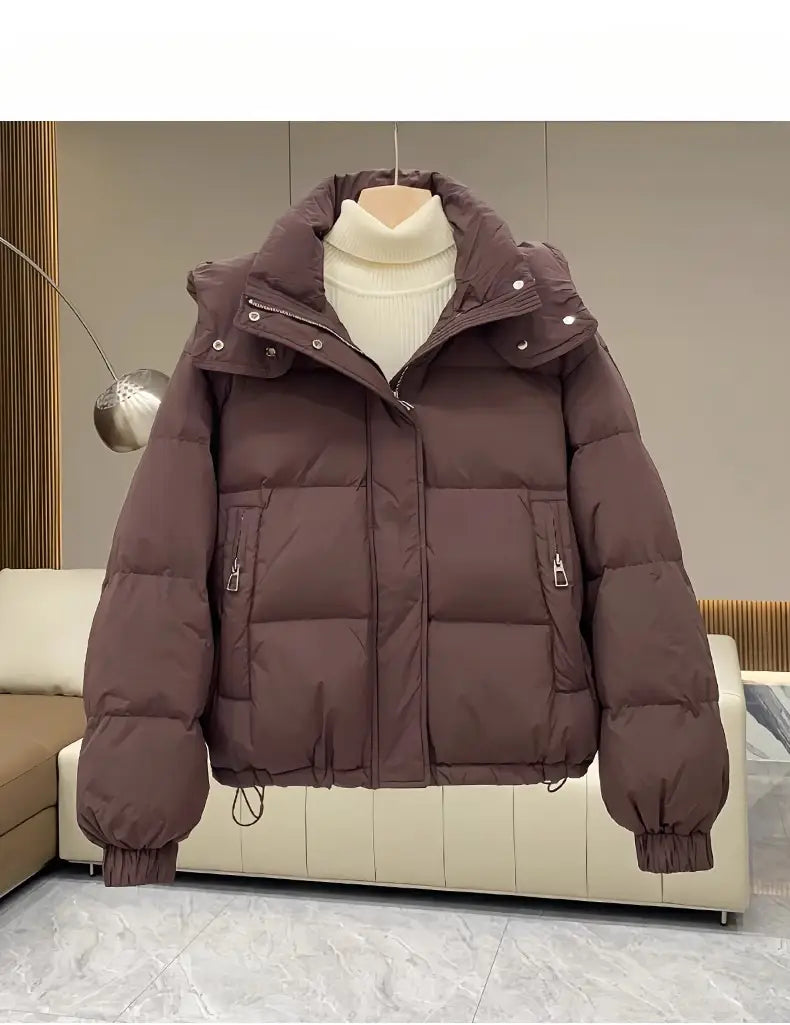 Brown women puffer jacket hooded quilted winter coat with front zipper closure and two side pockets.