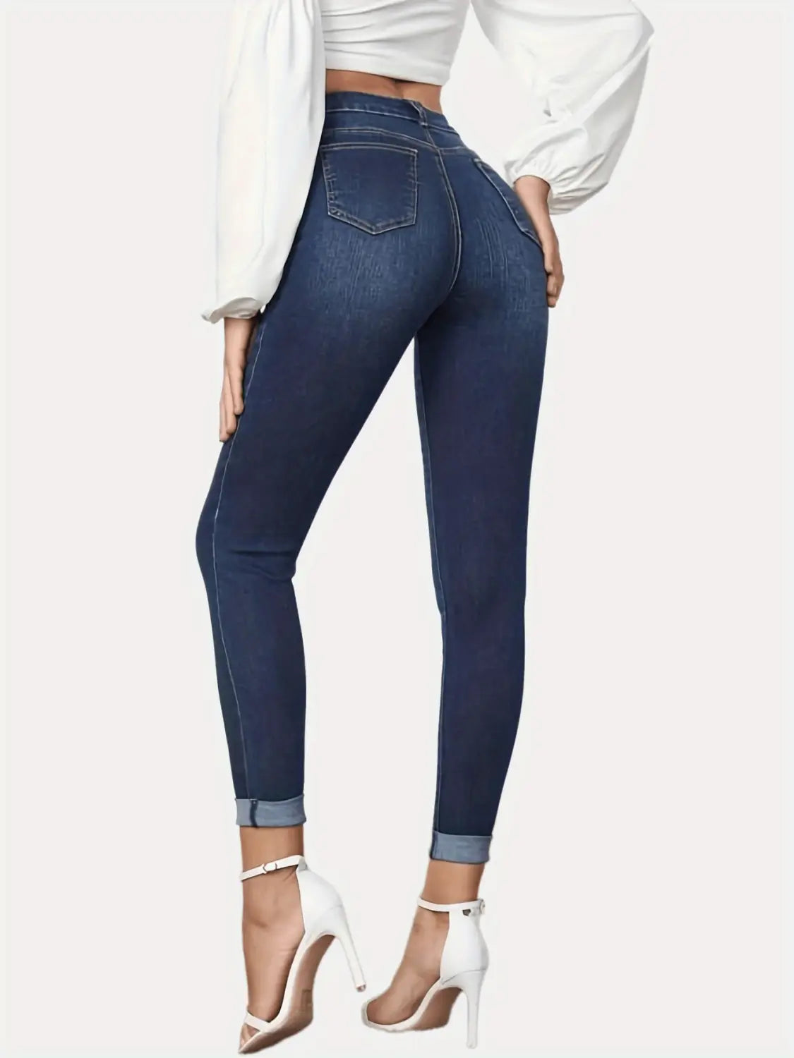 Jeans stretch raccourcis bleu foncé, coupe slim, présenté de dos : design skinny taille haute avec bas de jambe retroussés et poches arrière classiques