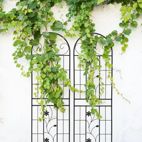 black wrought iron metal garden trellis 2 pack rustproof butterfly design 71in with arched top and floral vine patterns adorned with cascading green ivy
