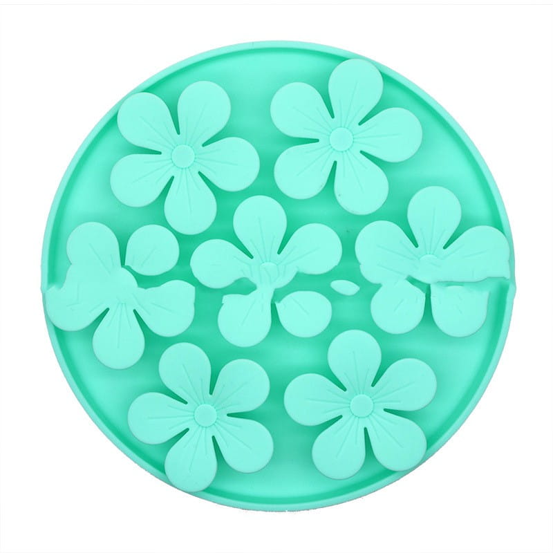 Tapis à lécher en silicone pour animal de compagnie vert menthe, circulaire, avec plusieurs indentations en forme de fleur pour l’alimentation lente et la stimulation mentale.