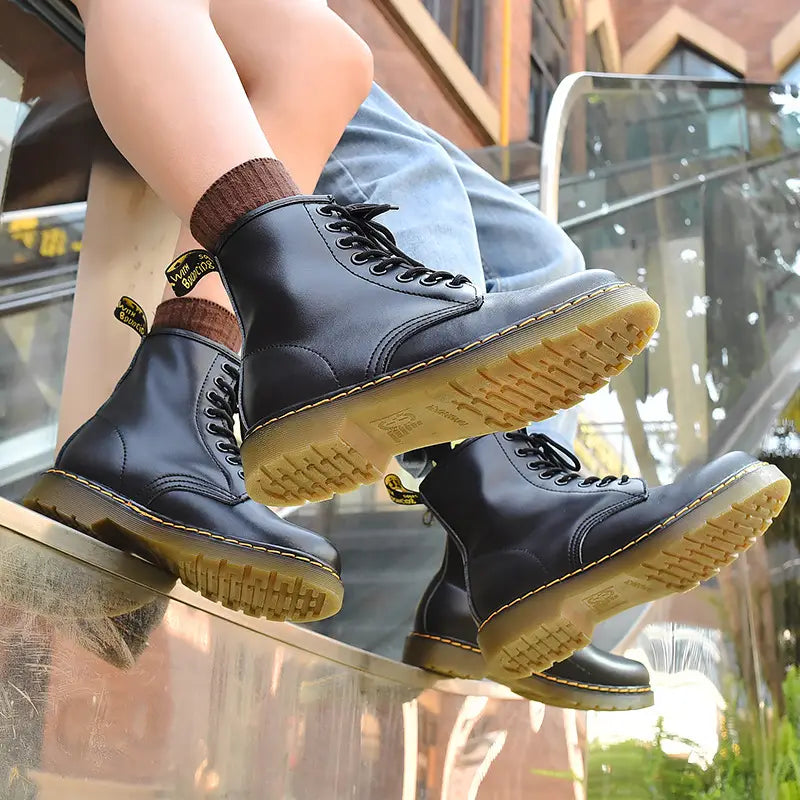 black leather martin boots featuring burgundy leather with yellow stitching displayed from the back side