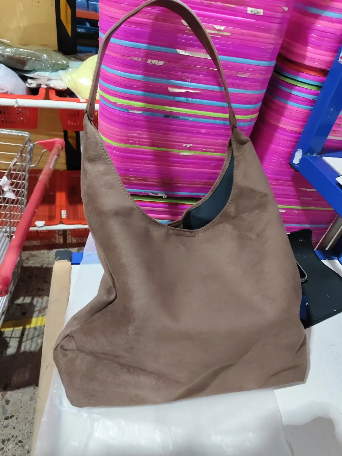 Brown suede shoulder bag with large capacity slouchy tote design featuring a single top handle and open front.