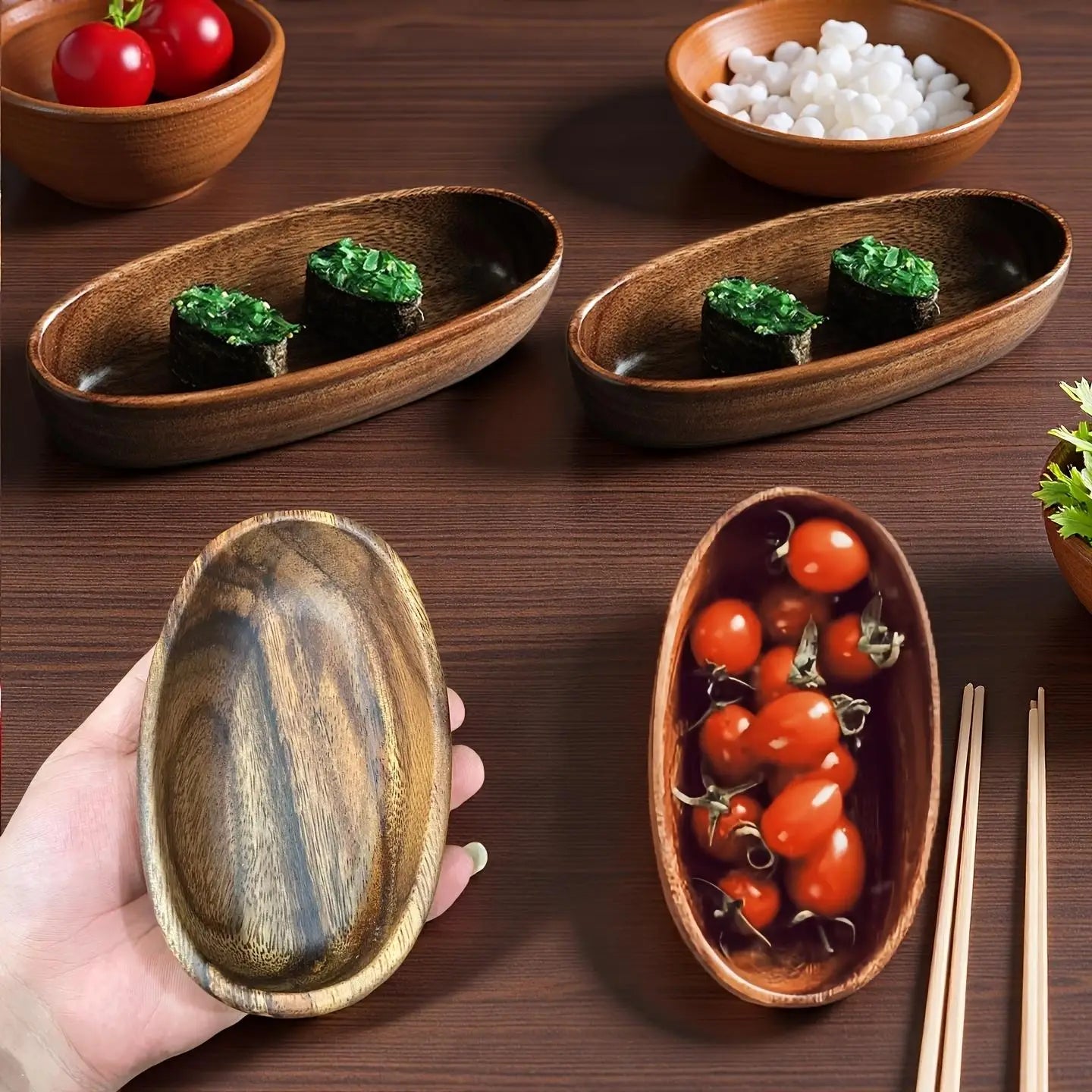 la mano sostiene un set de barco de madera artesanal para sushi japonés con forma ovalada y superficie lisa, con un acabado marrón oscuro y un patrón de vetas de madera natural