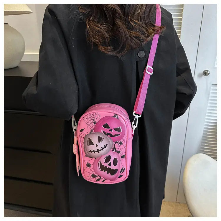 Pink embroidered Halloween floral and pumpkin crossbody bag featuring jack-o’-lanterns and spiderweb patterns for festive use.
