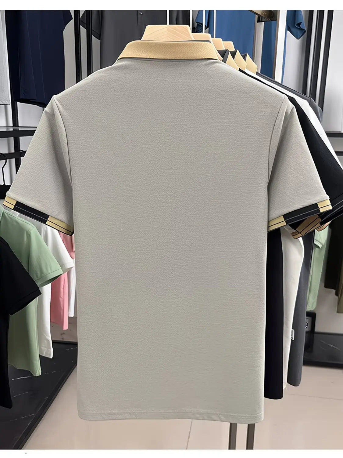 Mens slim fit polo shirt in light gray with a beige collar and sleeve cuffs accented by black and gold stripes, featuring short sleeves for a stylish casual look.