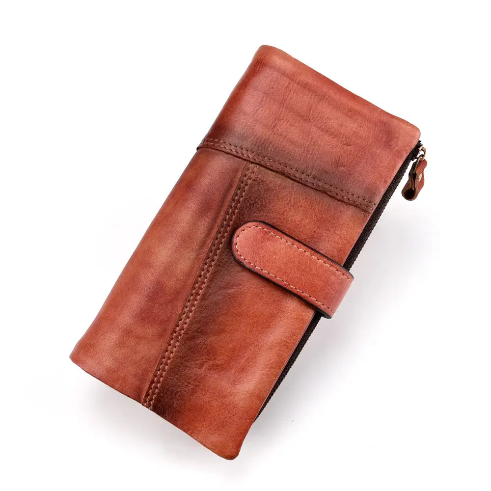 A brown leather long wallet with vintage stitching features a zipper closure and a flap strap for secure storage.
