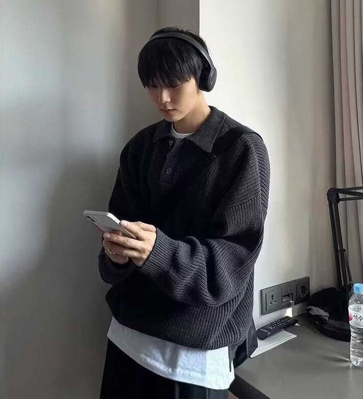 black knitted long sleeve polo sweater with collar and buttoned front worn over white shirt for men