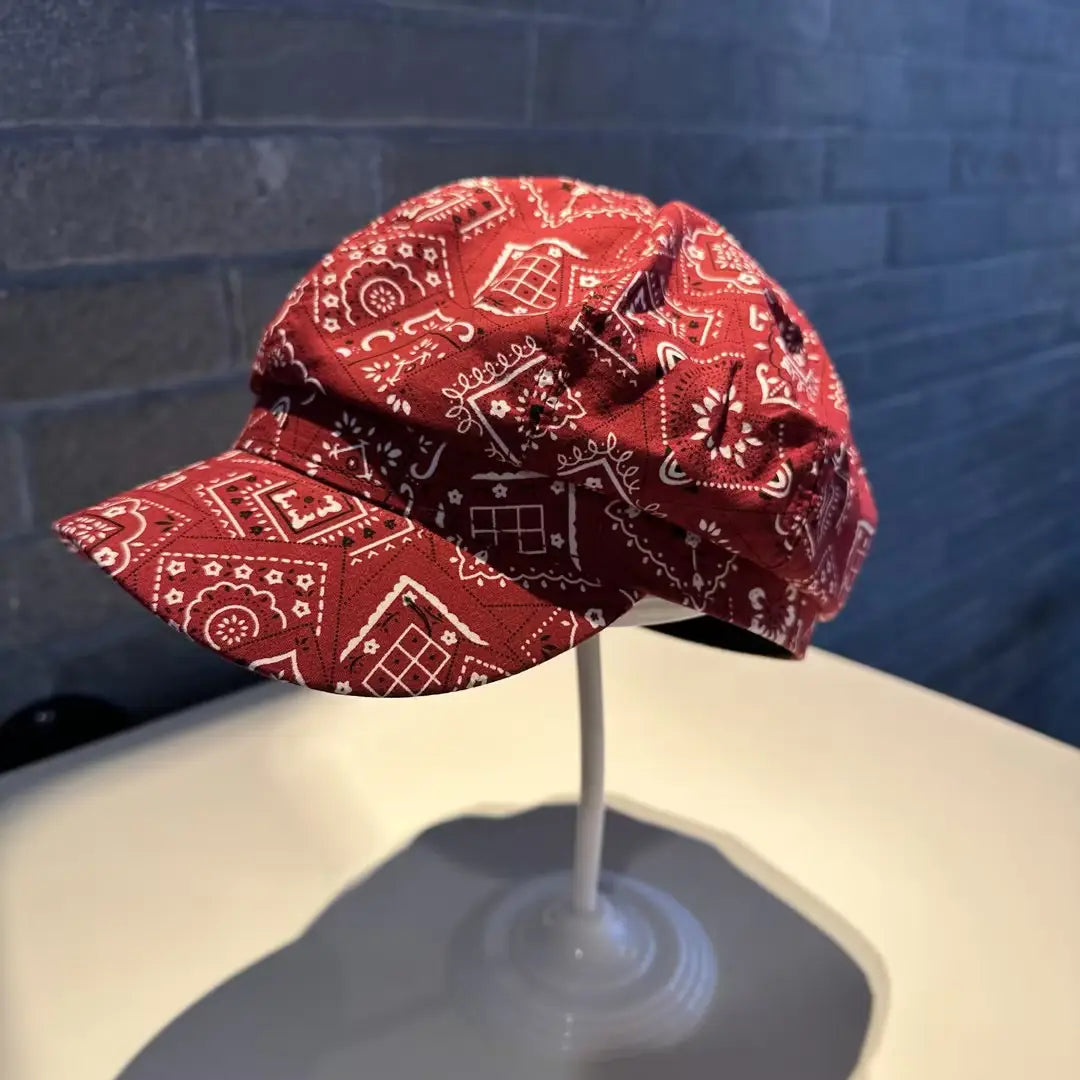 Floral newsboy cap for women featuring red bandana-patterned fabric with white geometric and floral designs.