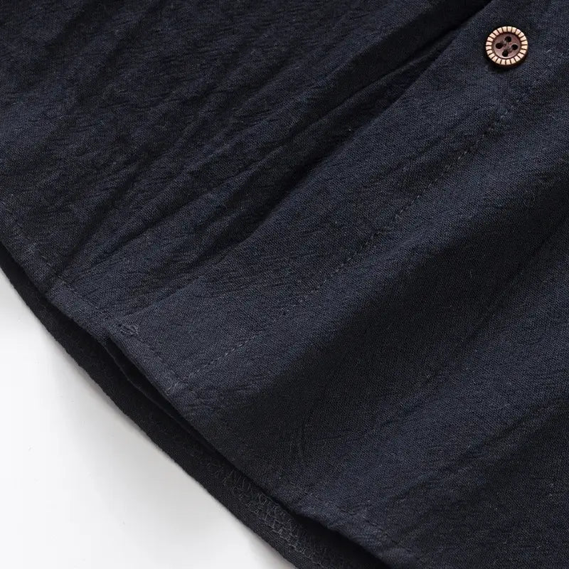 men’s dark blue linen blend sleeveless hooded button up shirt featuring a textured weave and brown wooden buttons.