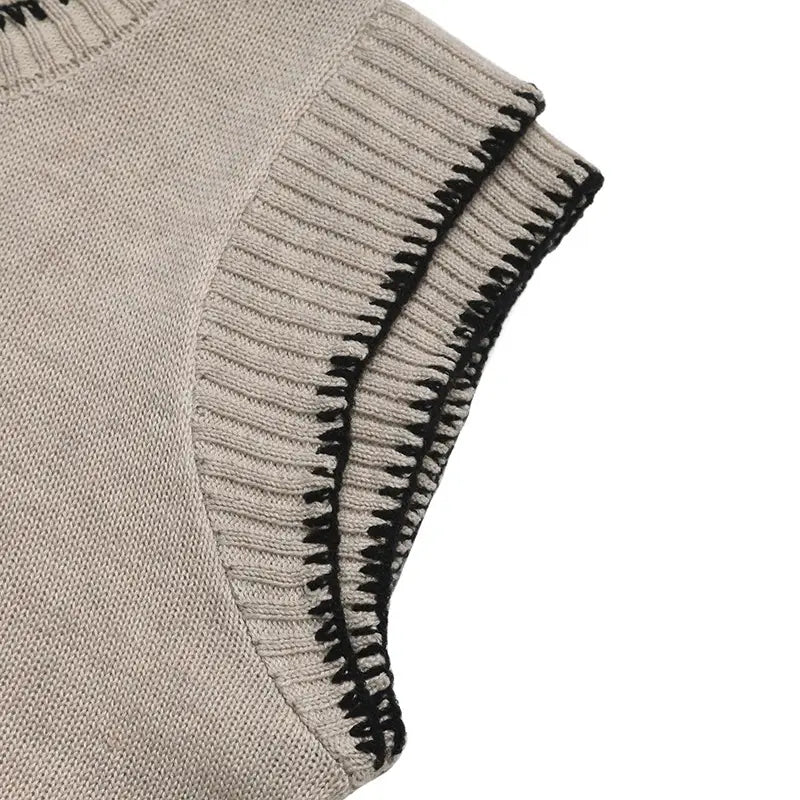Haut sans manches en maille beige avec texture côtelée et couture contrastante noire le long de l’emmanchure, conçu comme un haut sans manches tricoté à passepoil contrastant.