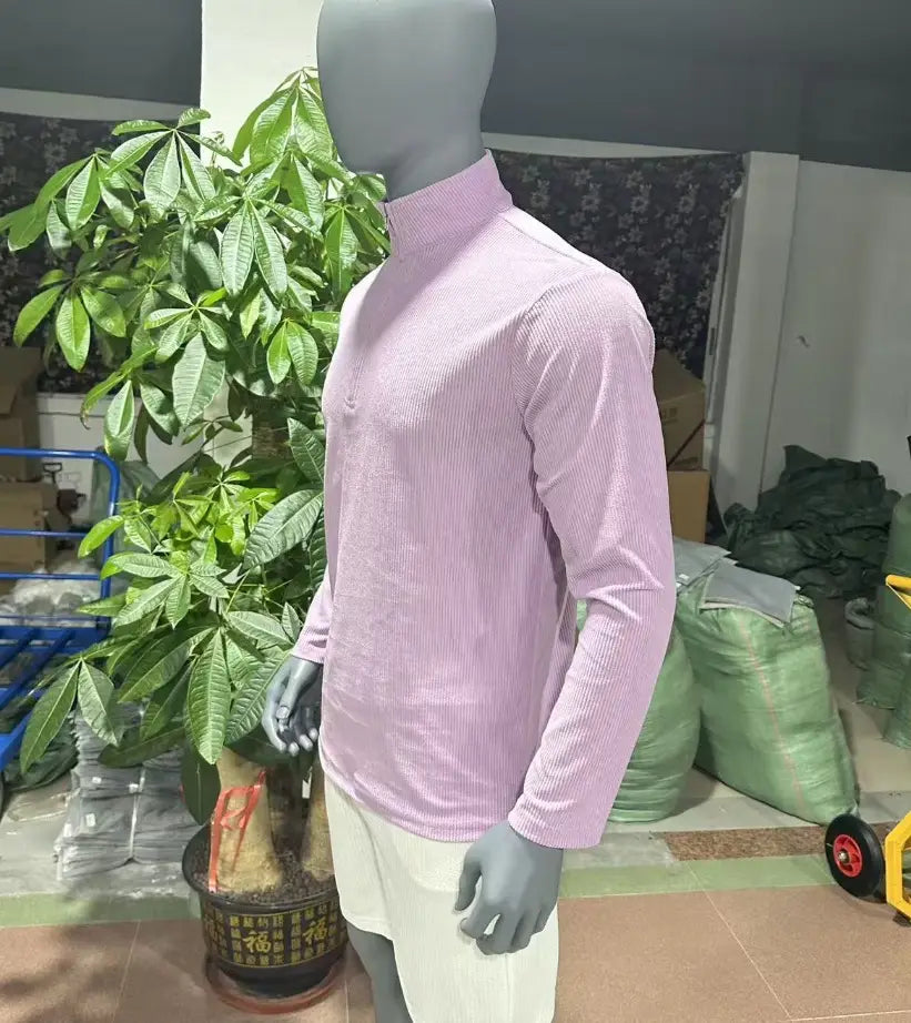 A light pink men’s ribbed knit half zip corduroy polo sweatshirt with a subtle vertical ribbed texture and long sleeves.