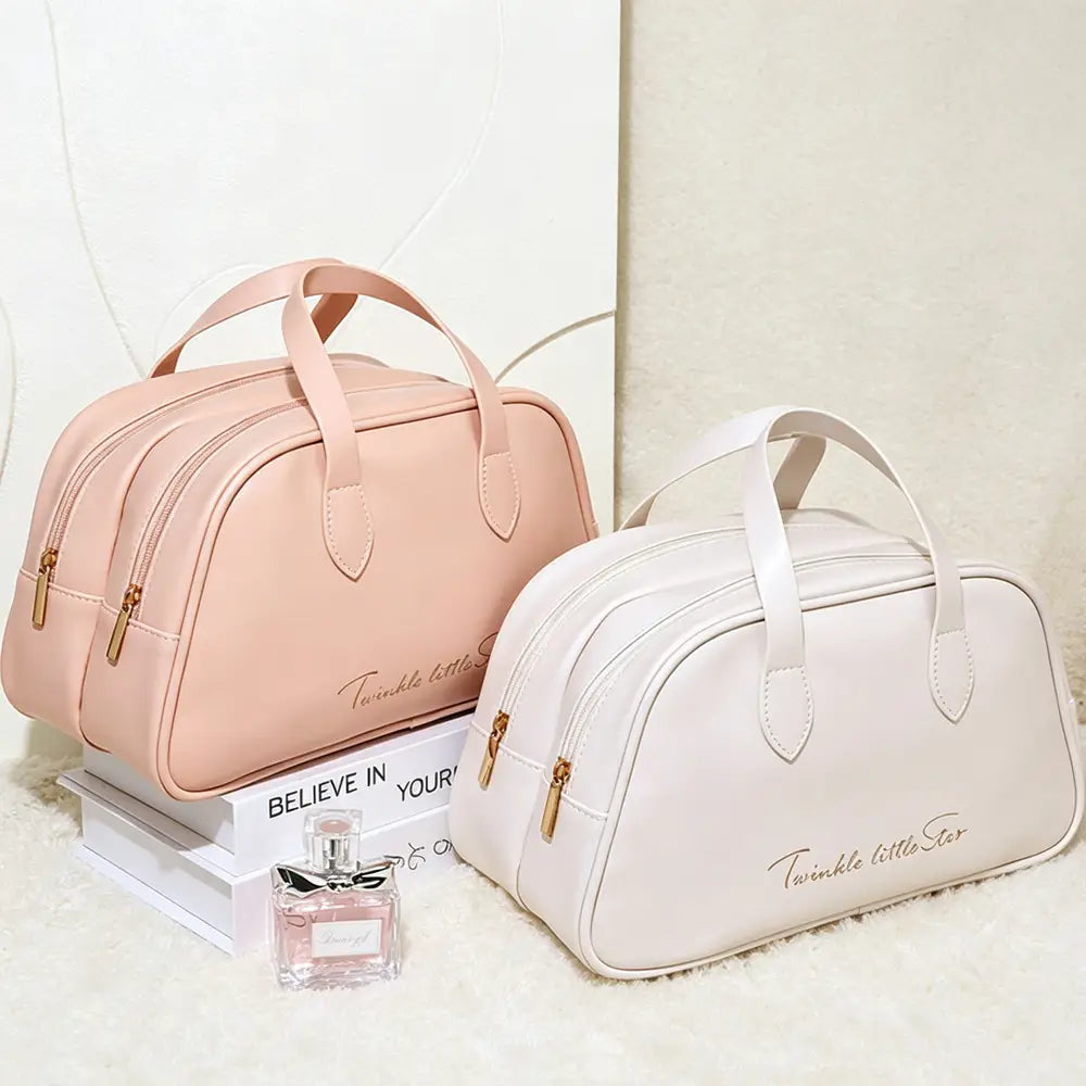 Un ensemble de trousses de maquillage de voyage rose et blanc avec des « petites étoiles scintillantes », comprenant des trousses de toilette en cuir imperméable avec des fermetures éclair dorées et des anses d’aspect cuir.