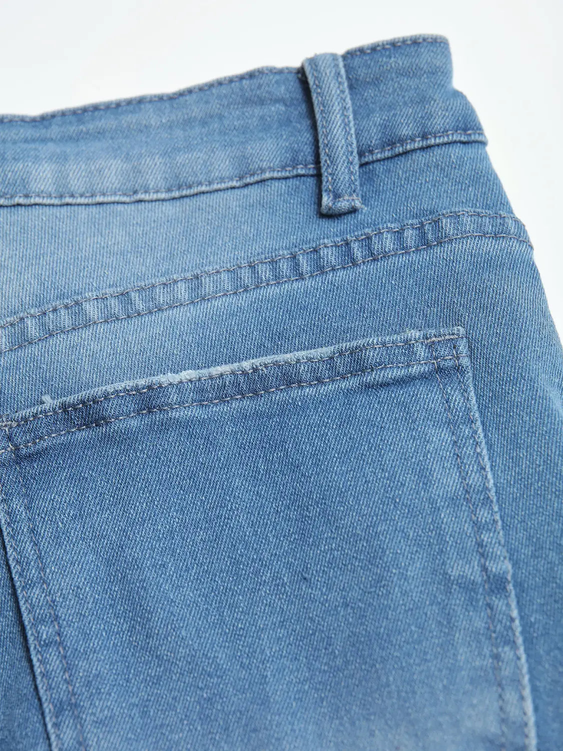 Men’s distressed slim fit stretch denim jeans in medium-wash blue denim shown from the back with a classic back pocket and stitched waistband.