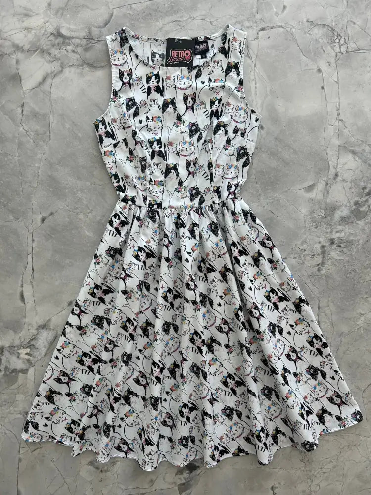 A sleeveless white cotton dress with black and gray cat print vintage 1950s style fitted waist flared skirt