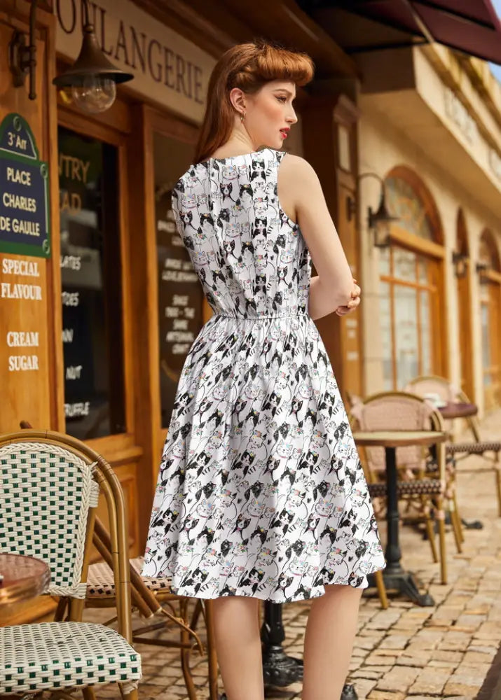 A white cotton sleeveless dress with a fitted waist and black cat print from Fabulous Felines vintage collection