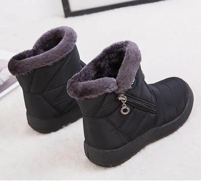 Bottes d’hiver imperméables matelassées noires, avec doublure intérieure moelleuse en fausse fourrure grise et un cordon de tirage décoratif en couleur argent.