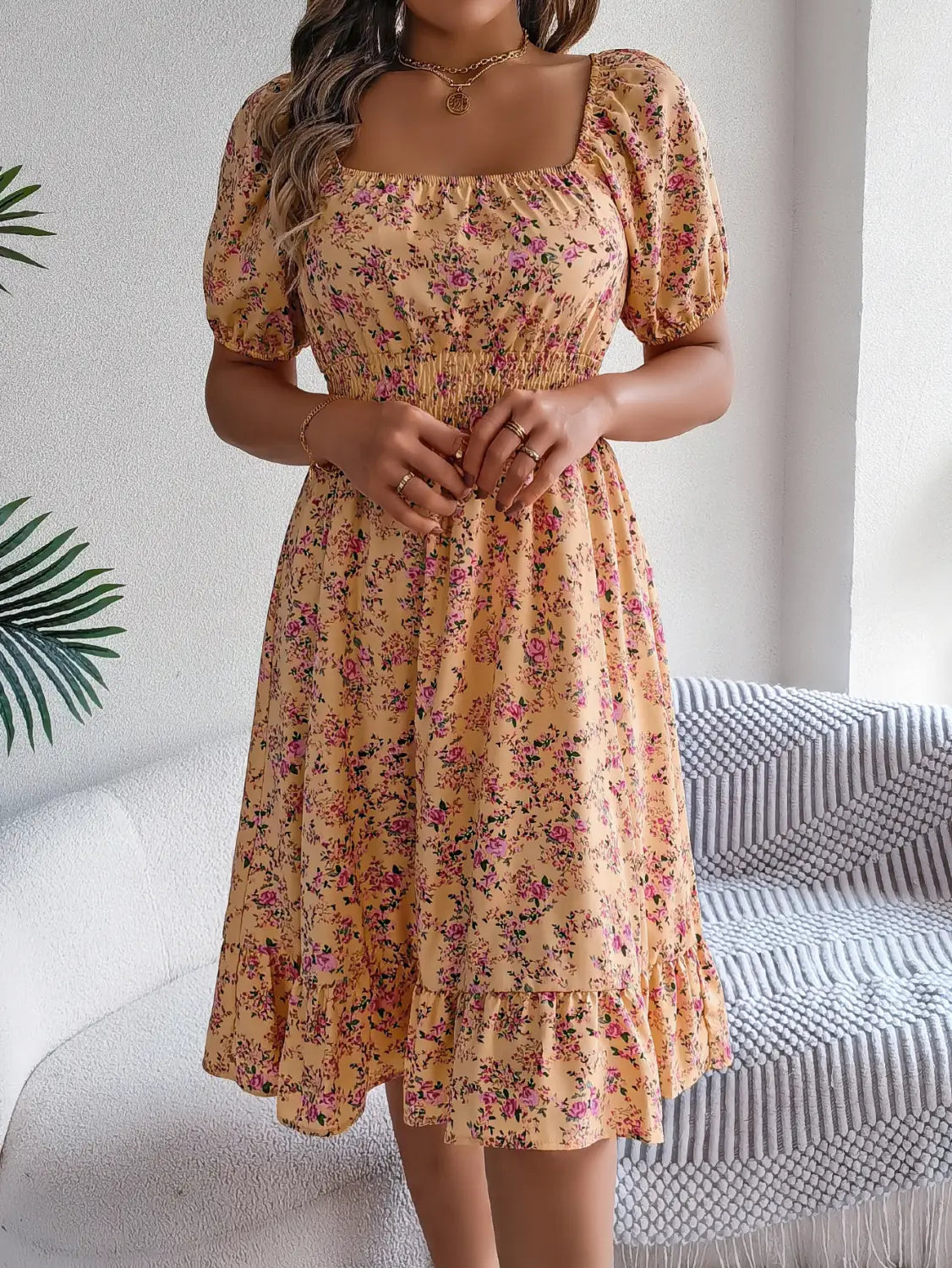 Robe d’été florale jaune pâle, avec manches courtes bouffantes et encolure carrée.