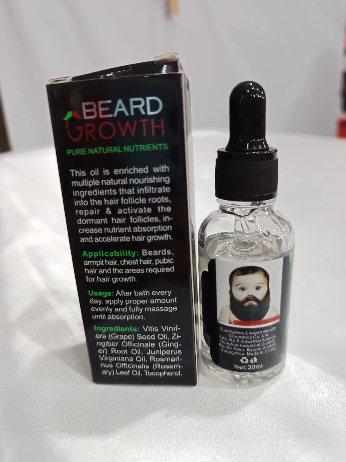 Clear glass bottle with black dropper cap and label featuring a bearded man’s face containing transparent beard growth oil for natural repair and nourishing care.