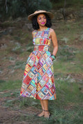 A vibrant sleeveless cotton midi dress with a colorful patchwork of vintage book covers titled Fairytales Bibliophile