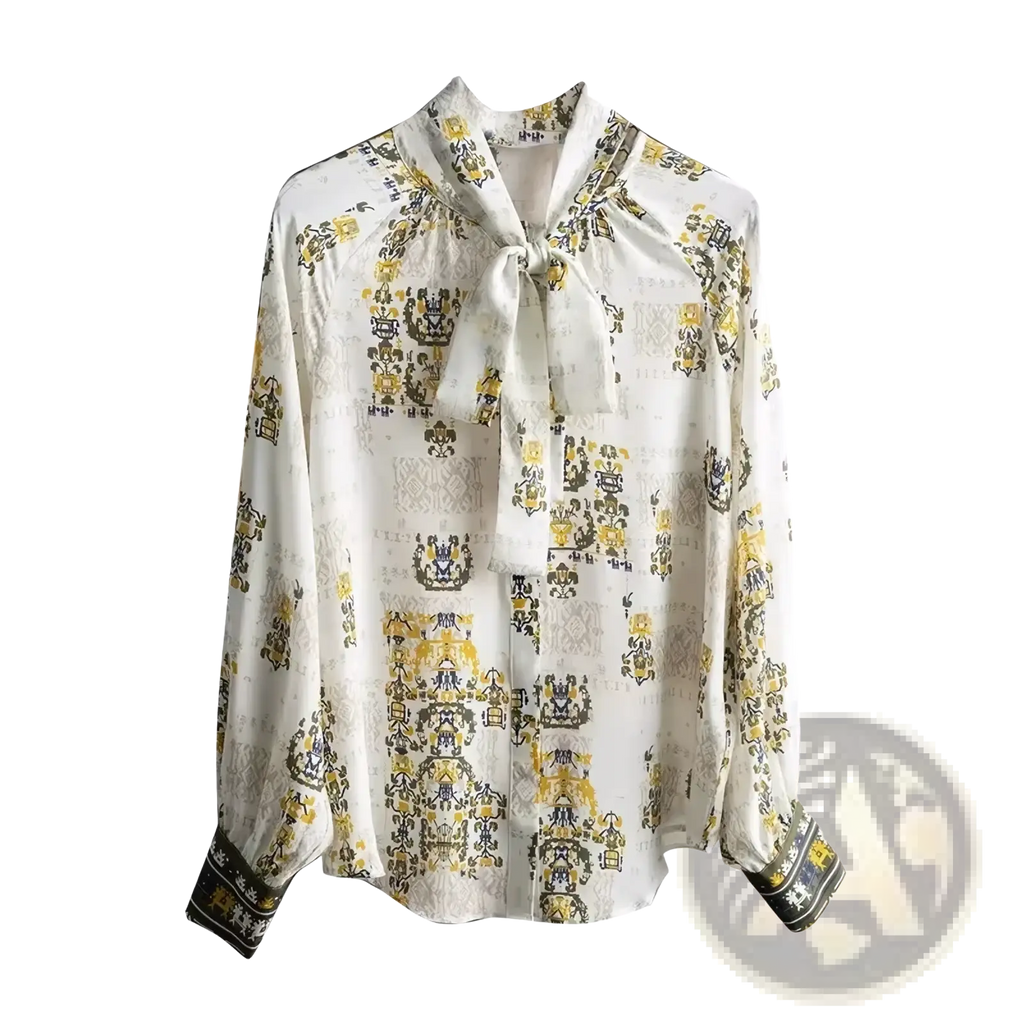A white silk Fanieces vintage print long sleeve blouse with a delicate yellow and black heraldic pattern and tied necktie detail
