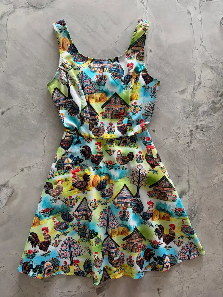 Folk art farm print sleeveless skater dress with pockets featuring roosters and rustic houses on turquoise and yellow background