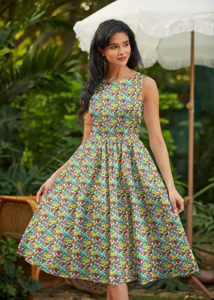 Sleeveless knee-length vibrant green cotton midi dress with colorful floral pattern and pockets, perfect for farmers market